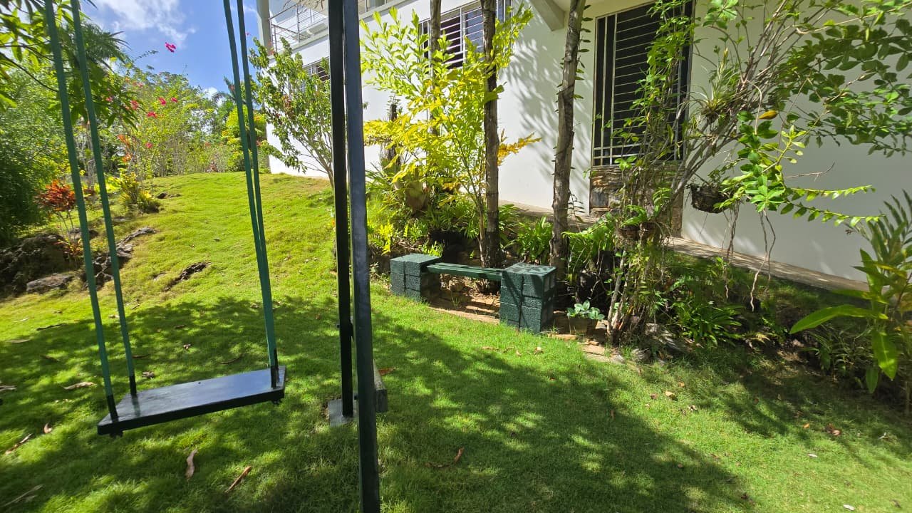 Villa en el limon (14) Columpio negro en jardÃn junto a una casa blanca