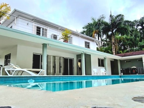 Villa tropicale bianca con piscina esterna e palme