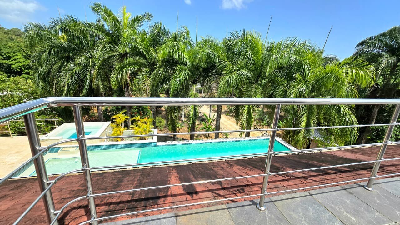 Villa en el limon (20) Piscina tropical vista desde terraza con barandilla metálica