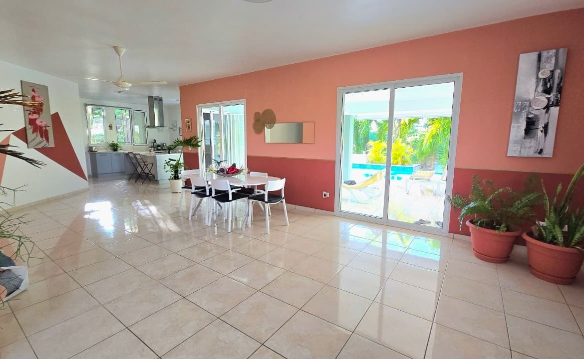 Salón comedor luminoso con acceso a piscina tropical