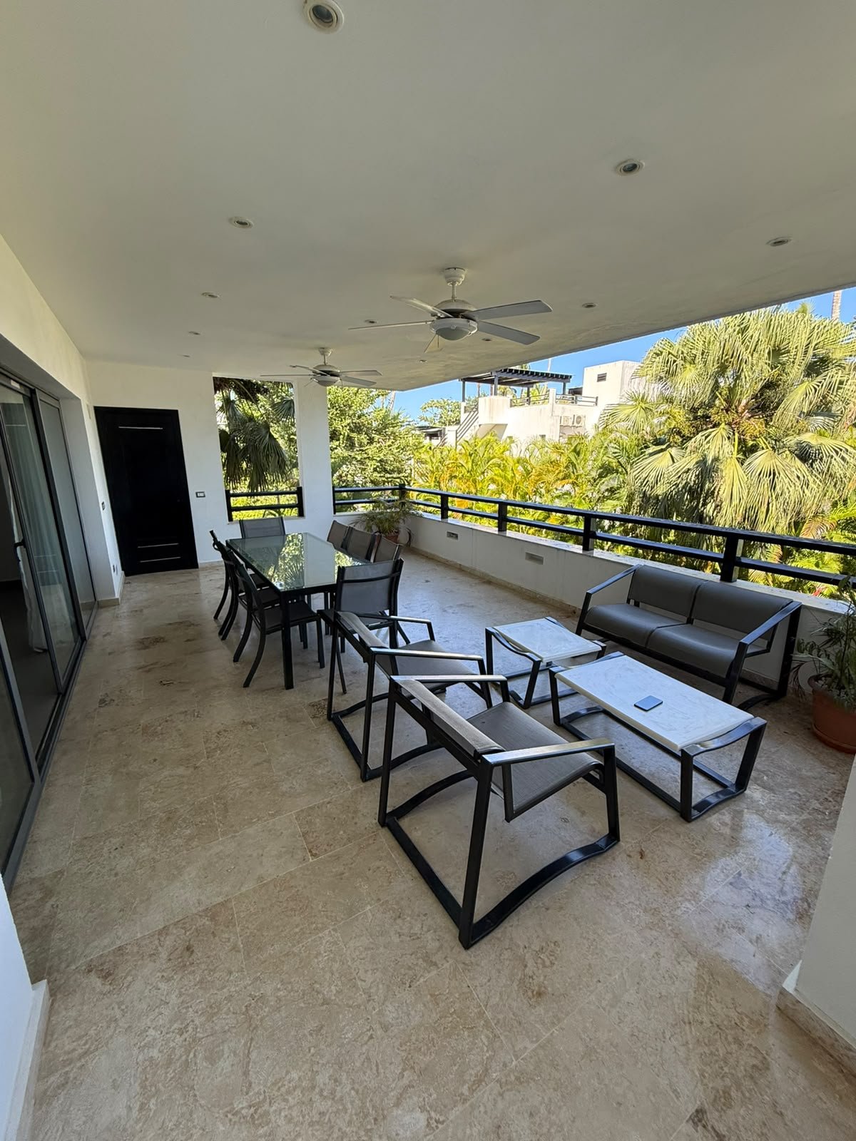 Apartamento Aligio (11) Terraza cubierta con mobiliario moderno y palmeras