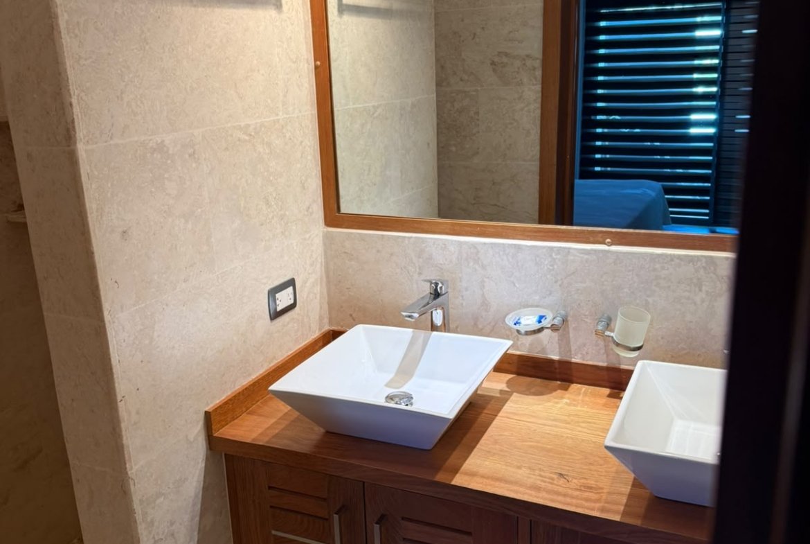 Baño moderno con lavabo blanco y mueble de madera
