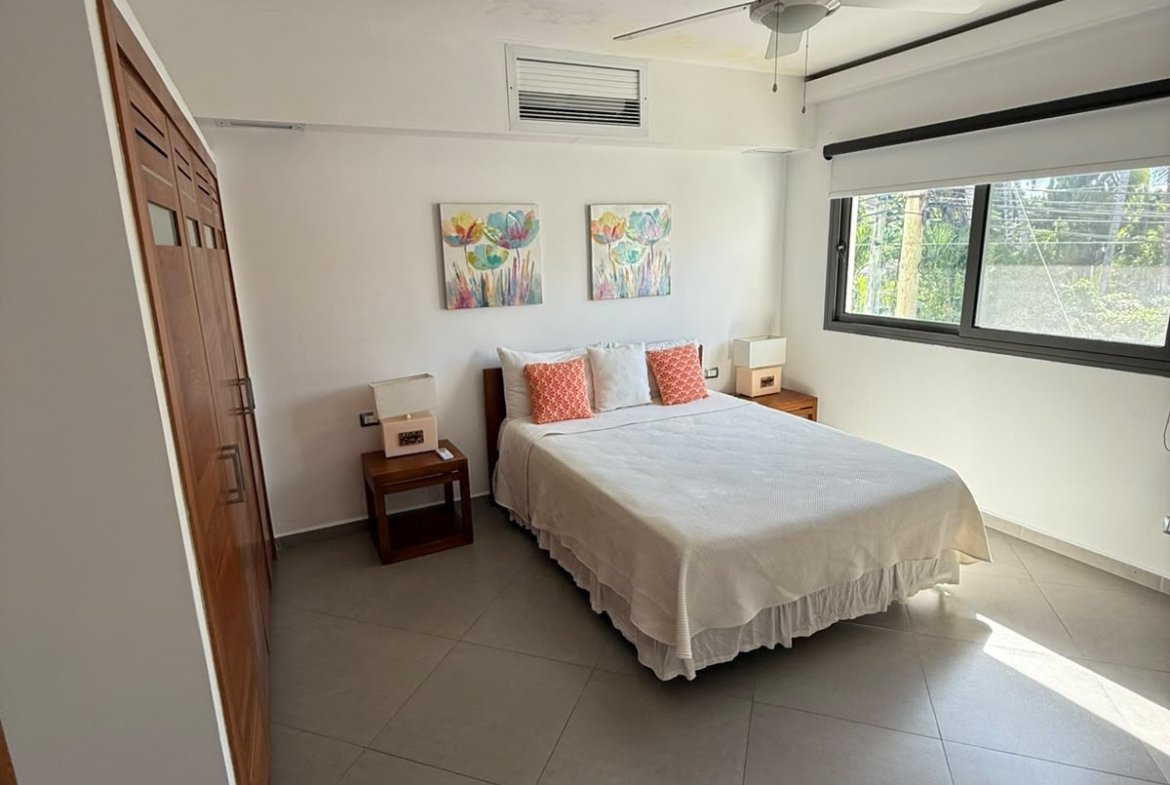 Dormitorio luminoso con cama doble, armario y gran ventana