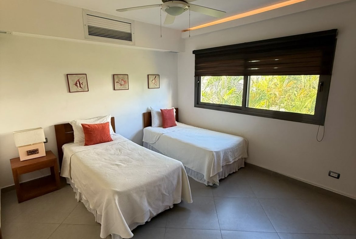 Dormitorio luminoso con dos camas individuales y ventana grande