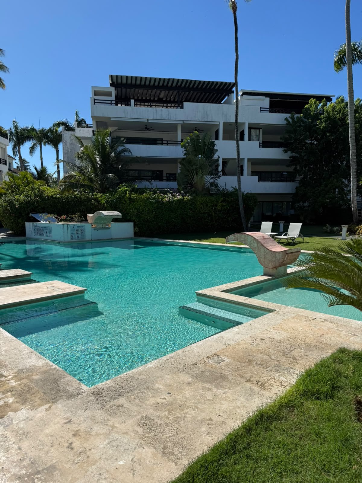 Piscina tropical frente a moderno edificio residencial