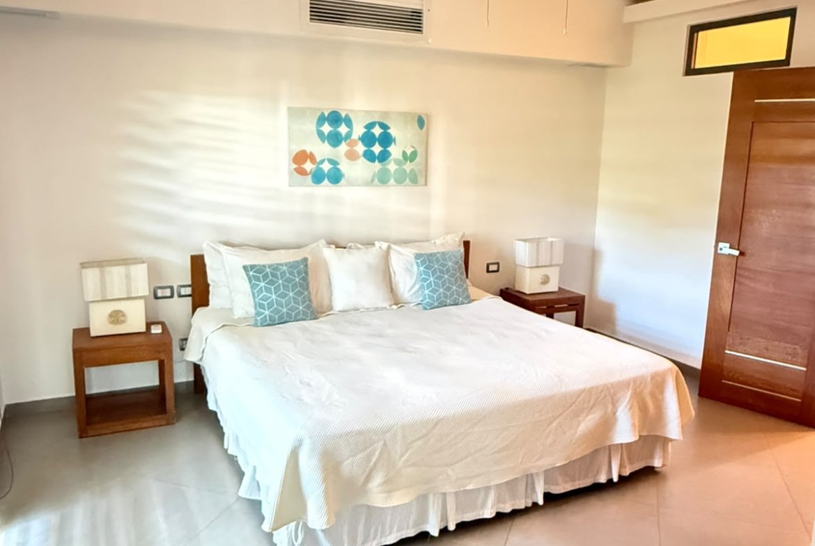 Dormitorio luminoso con cama doble, ventilador y mesillas