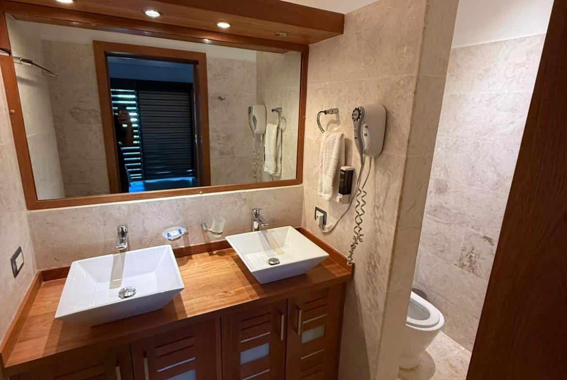 Baño elegante con doble lavabo y muebles de madera