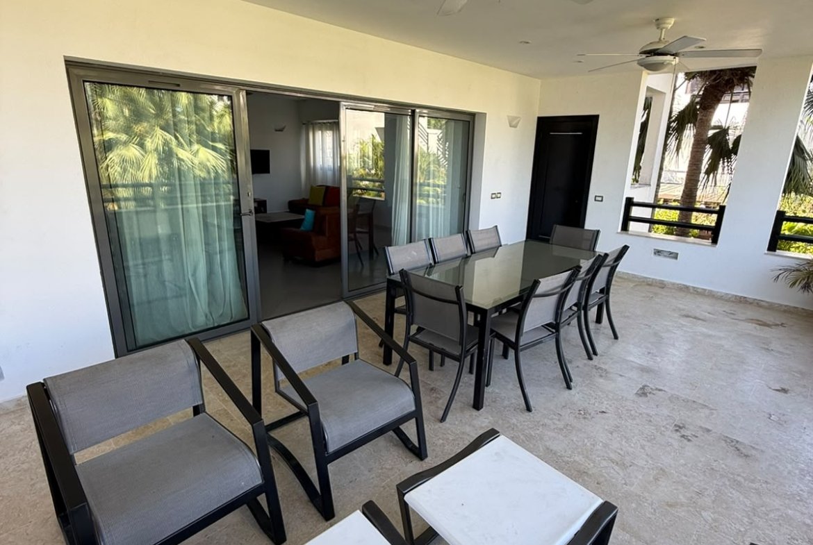 Terraza cubierta con comedor, ventiladores y vistas tropicales