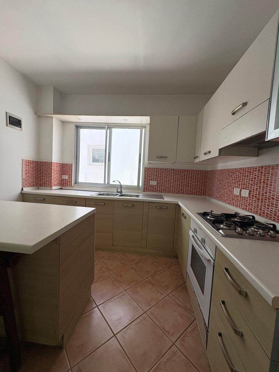 Apartemento Piattini (12) Cocina moderna compacta con muebles claros y azulejos rojos