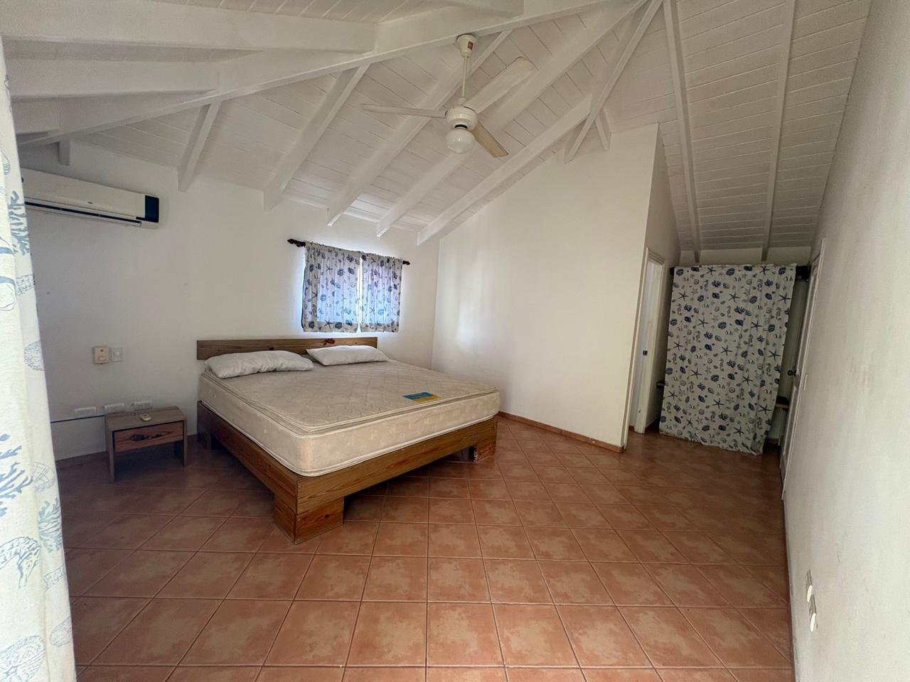 Apartemento Piattini (2) Dormitorio amplio con cama, techo abuhardillado y ventilador
