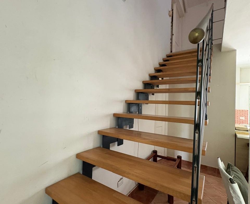 Escalera interior de madera con barandilla metálica negra