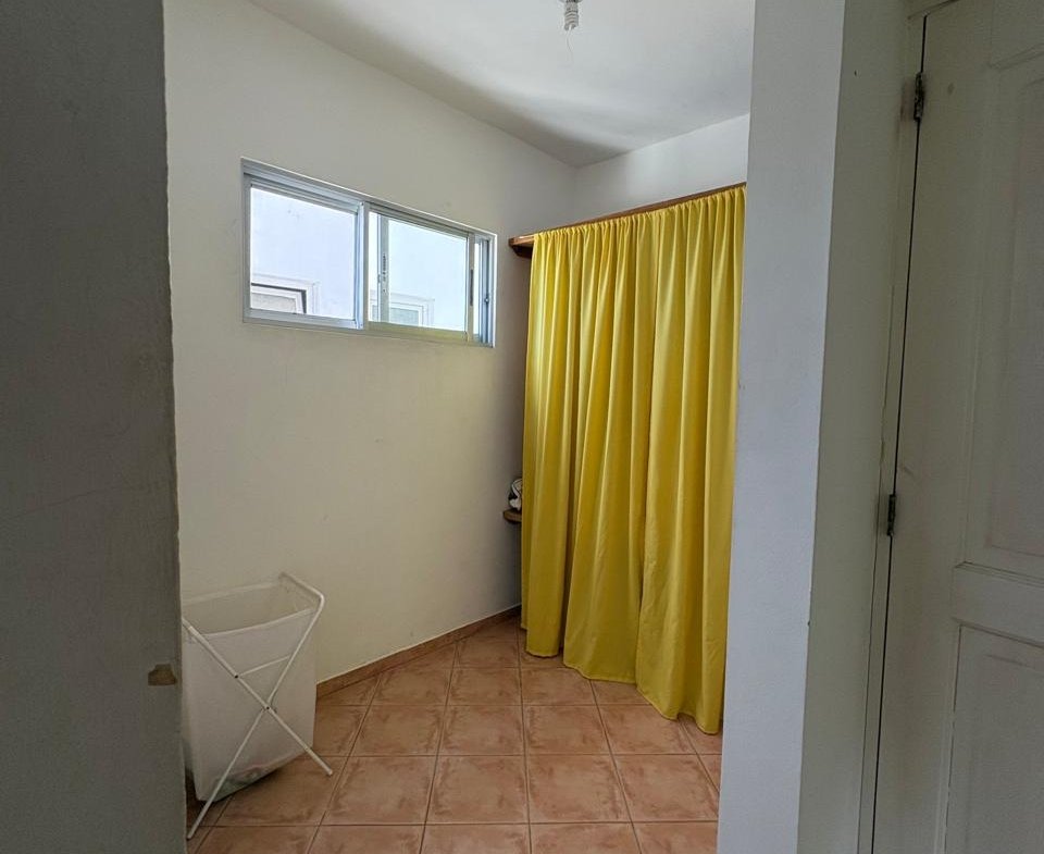 Baño luminoso con cortina amarilla y suelo cerámico