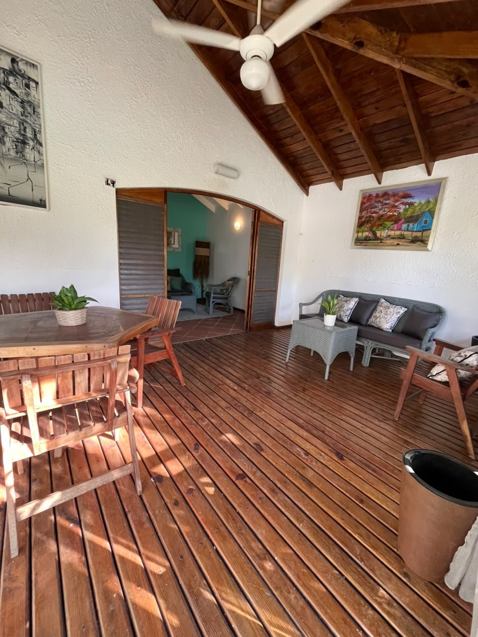 India Canela (3) Véranda en bois avec salon, table et ventilateur plafond