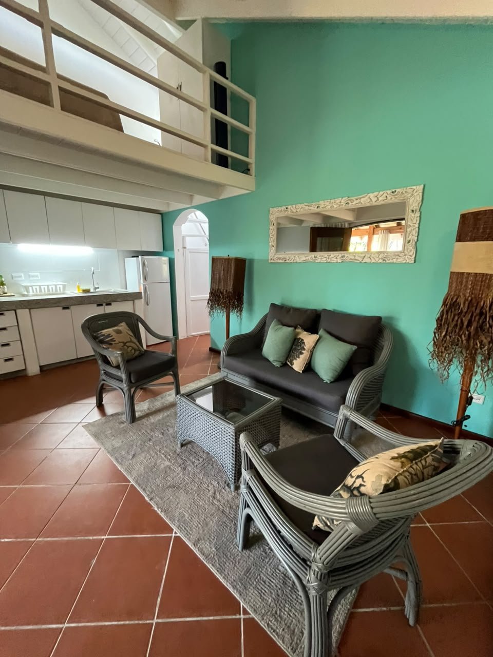 India Canela (4) Salon turquoise avec mezzanine, kitchenette et mobilier en rotin