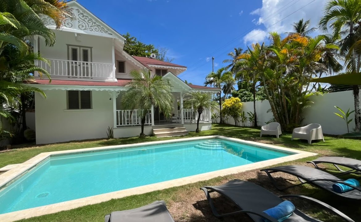 Villa tropical blanca con piscina y palmeras