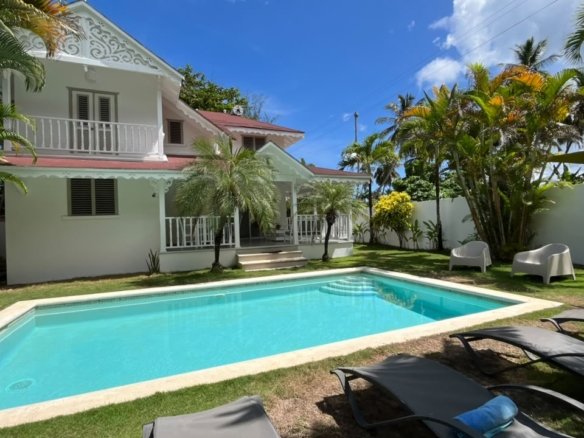 Villa tropical blanca con piscina y palmeras
