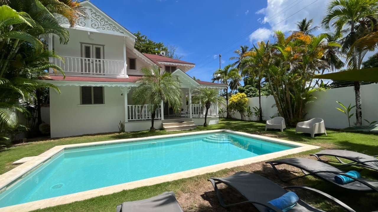 Villa tropical blanca con piscina y palmeras