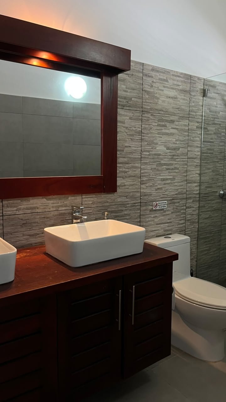 Baño moderno con lavabo sobre mueble de madera
