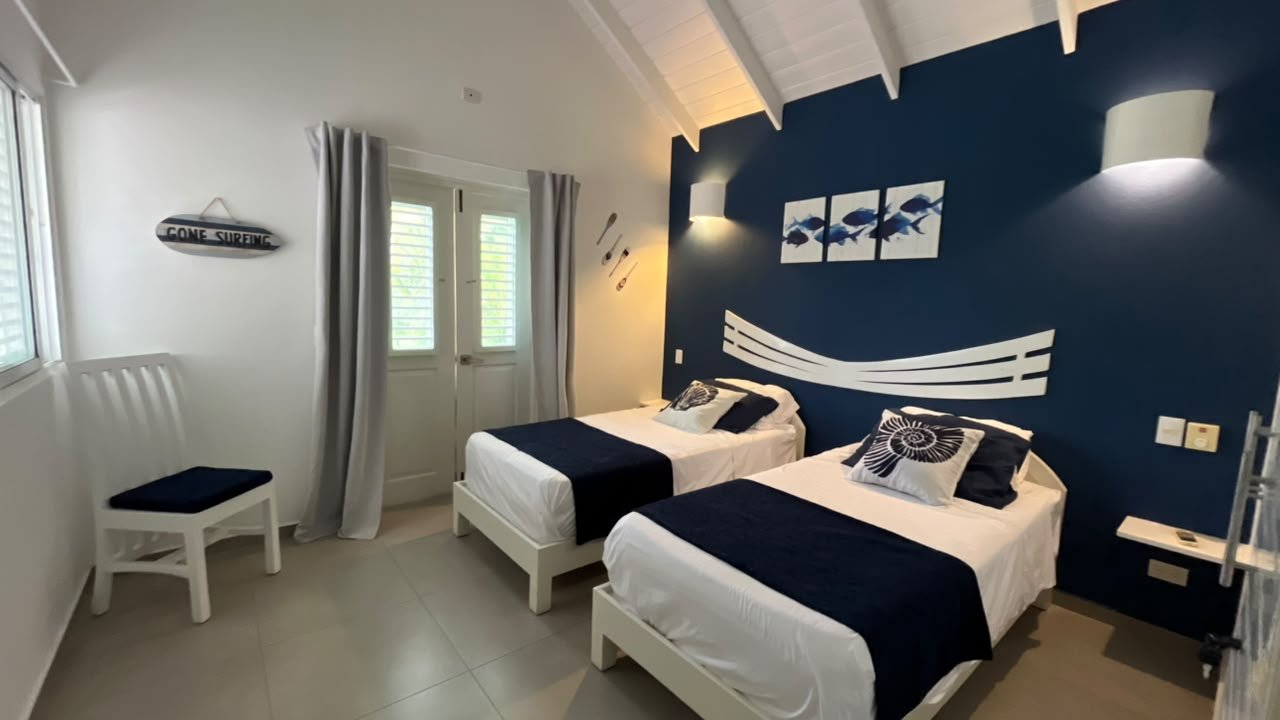 Dormitorio con dos camas y decoración marinera azul