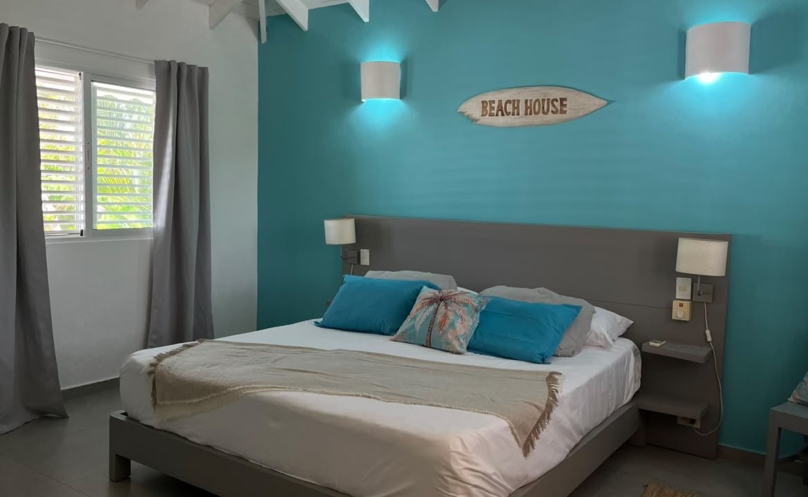 Dormitorio moderno con pared turquesa y cama doble