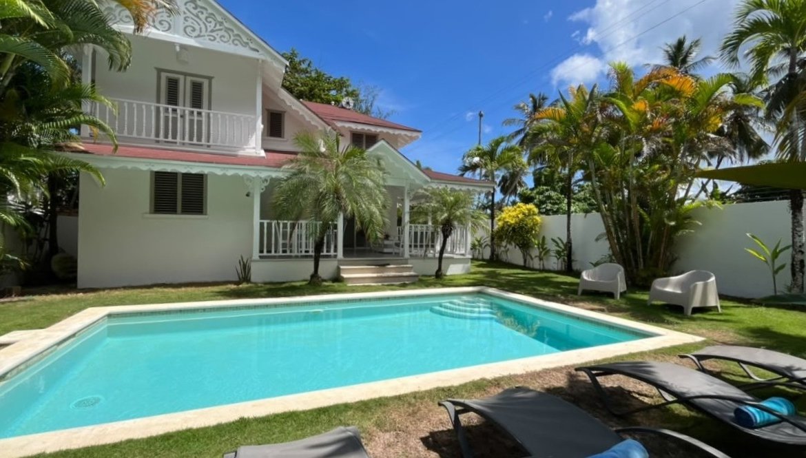 Villa tropical blanca con piscina privada y palmeras