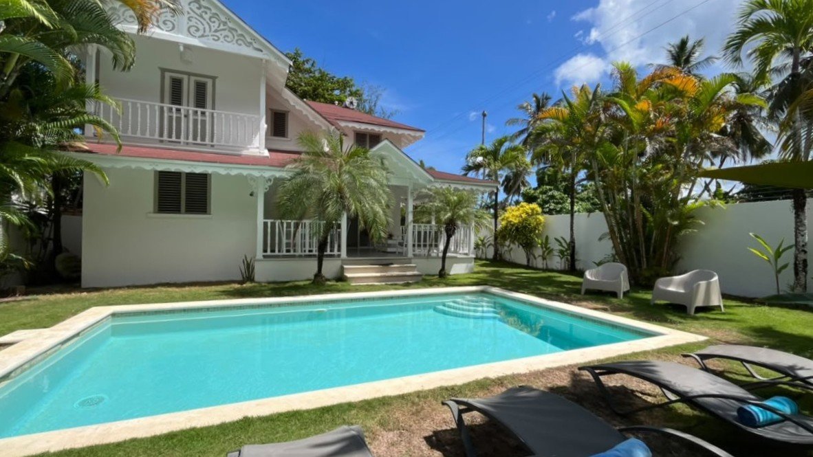 Villa tropical blanca con piscina privada y palmeras