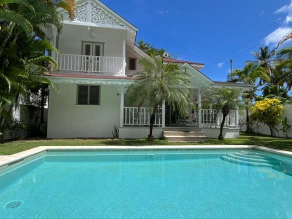 Villa blanca tropical con piscina privada y palmeras