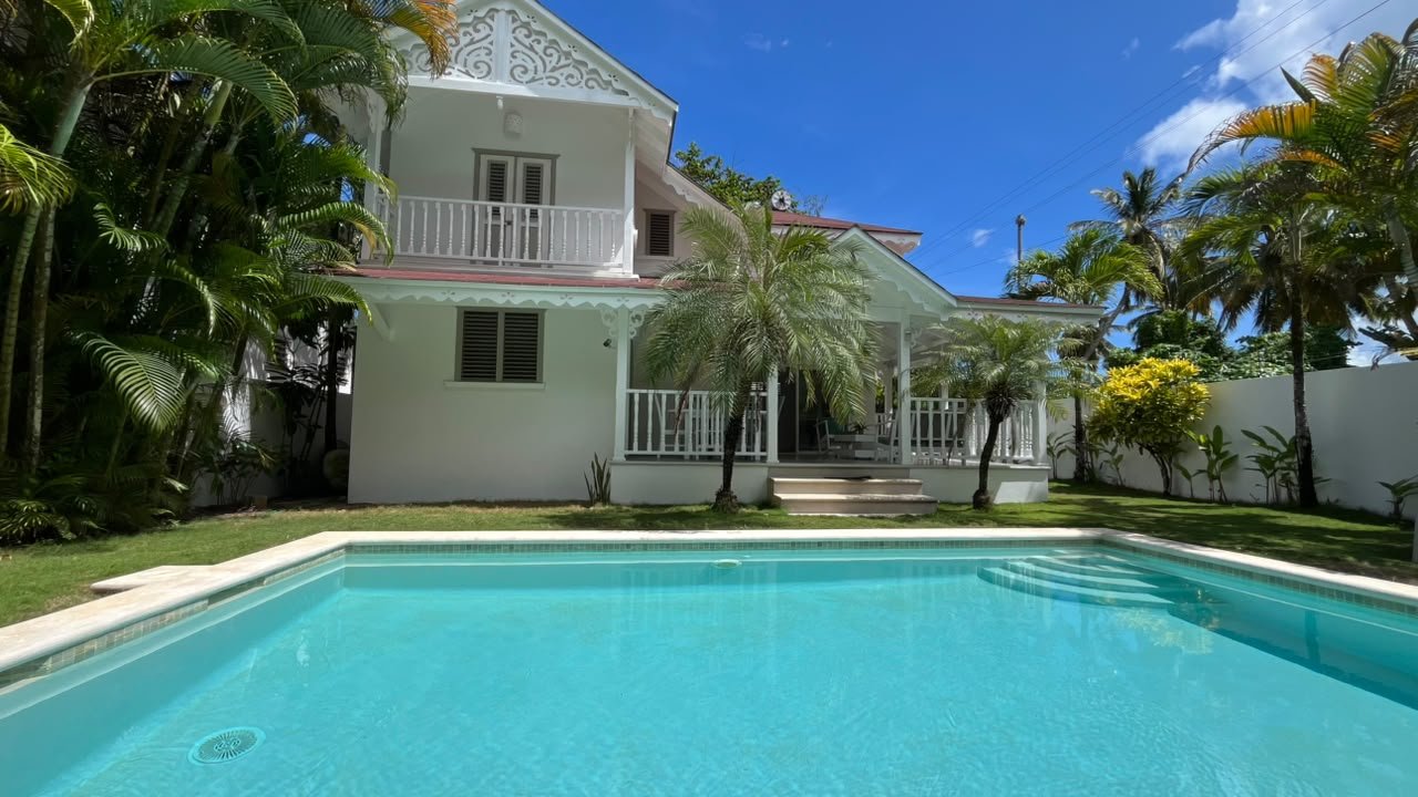 Villa blanca tropical con piscina privada y palmeras