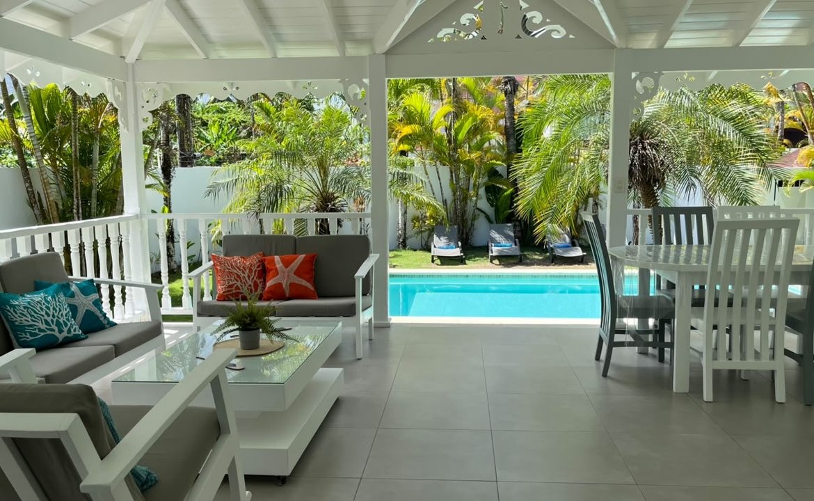 Terraza cubierta con piscina y jardín tropical