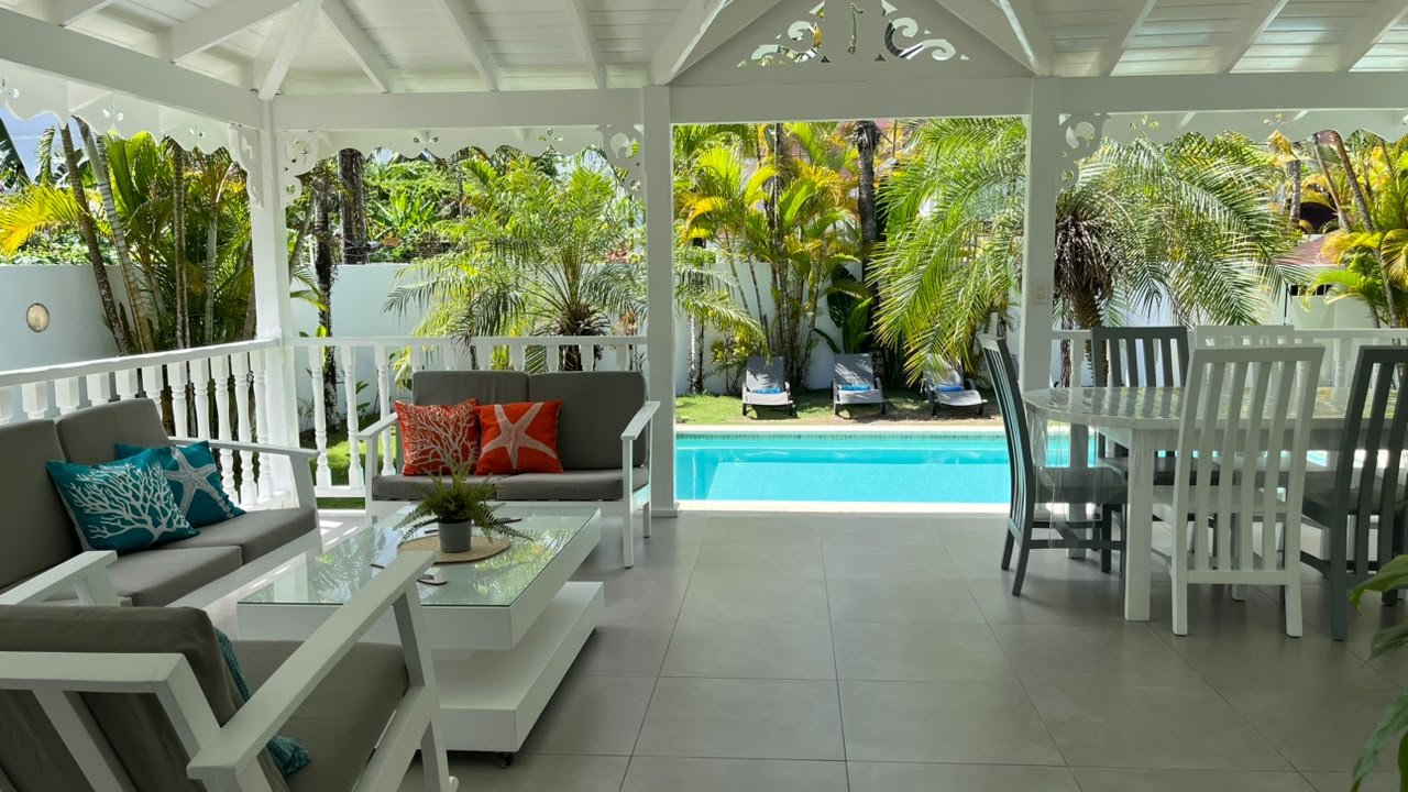 Terraza cubierta con piscina y jardín tropical